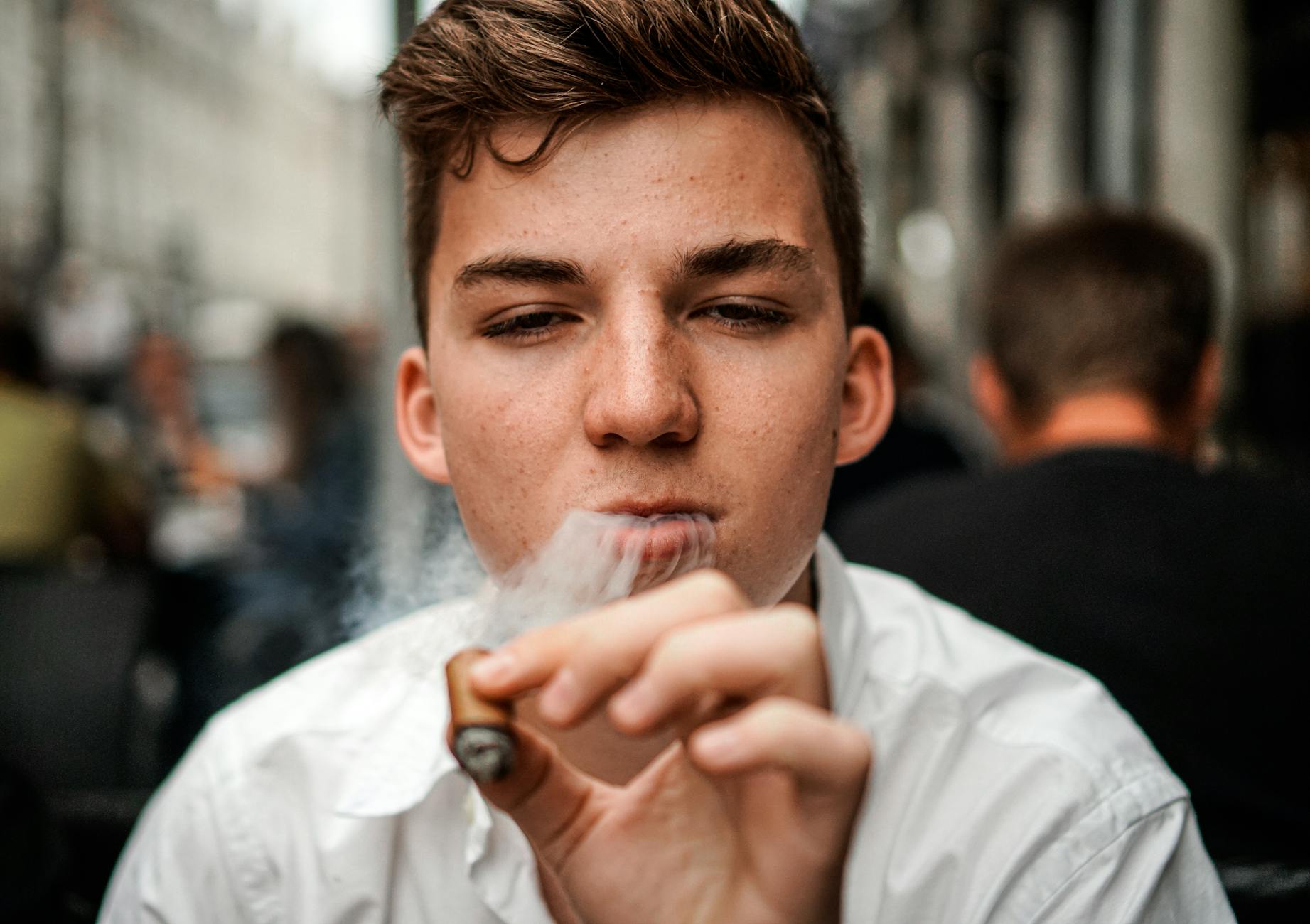 man smoking cigar close up photography